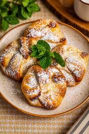 Traditional Romanian poale-n brâu pastries with golden-brown dough folded around a sweet cheese and raisin filling.